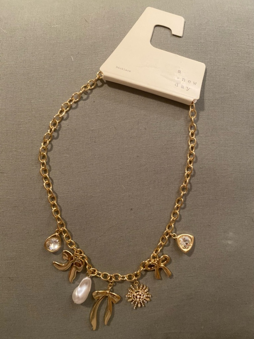 a new day Gold Charm Necklace with Pearl, Crystal & Bow Accents